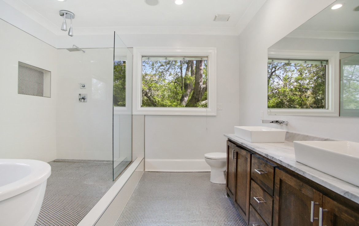 Bathroom featuring stand-in shower, tub, and double sinks