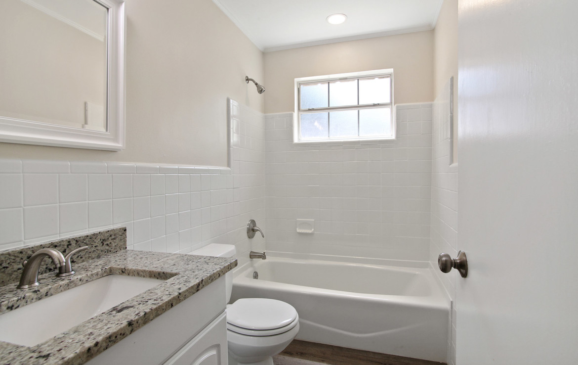 Bathroom featuring white tiles and granite
