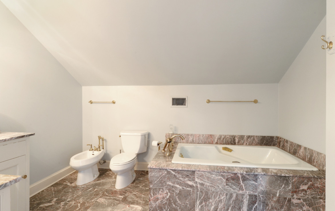Bathroom with marbled bathtub , toilet and bidet