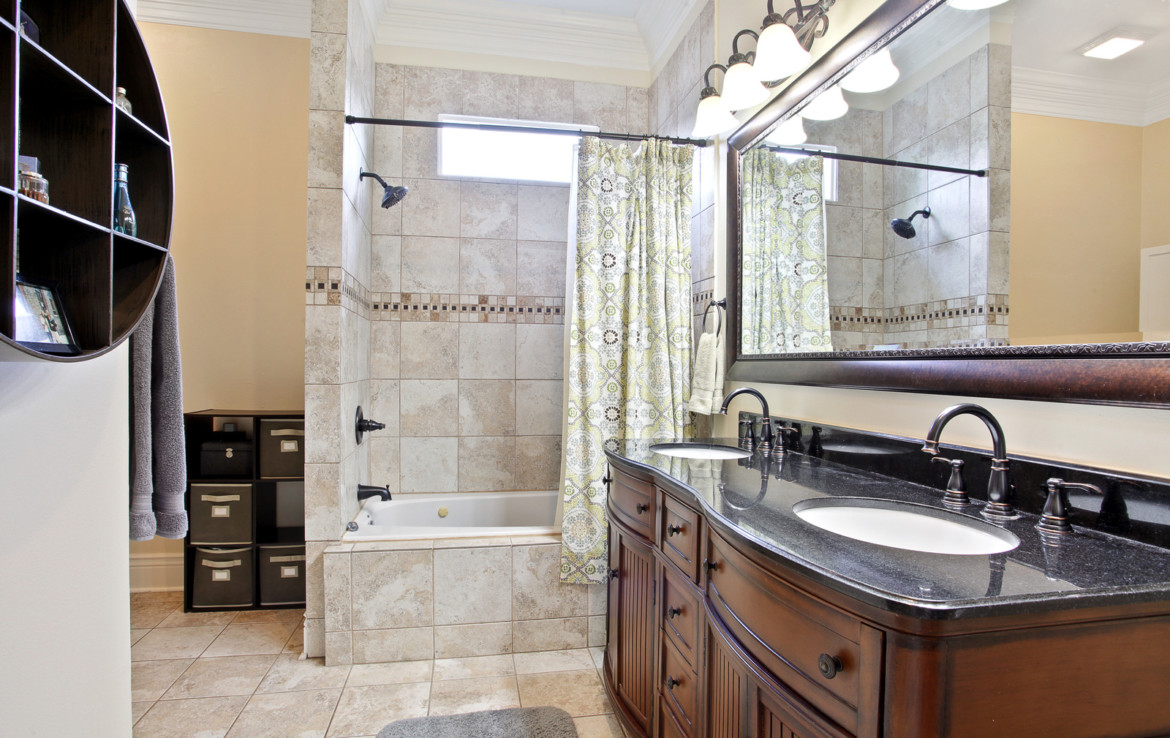 view of bathroom bathtub and double sink vanity