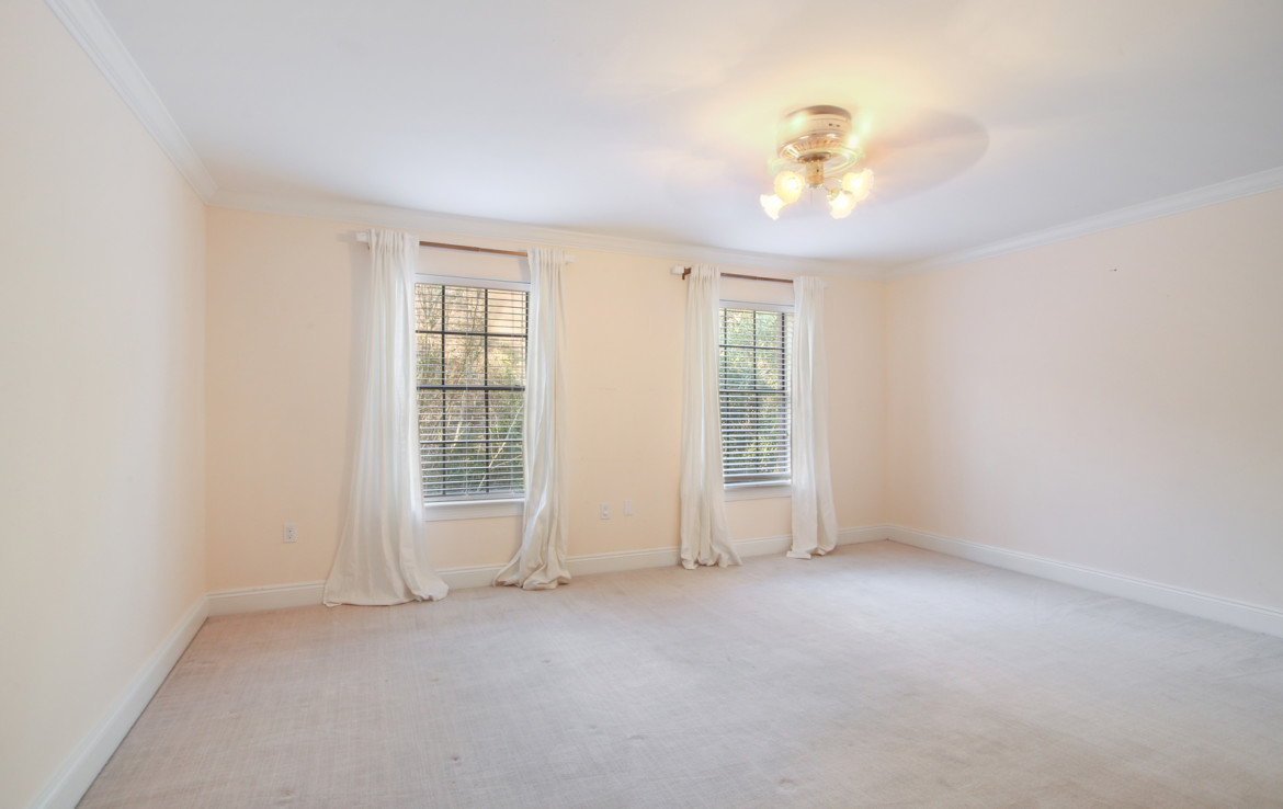 Unfinished bedroom with white curtains on window