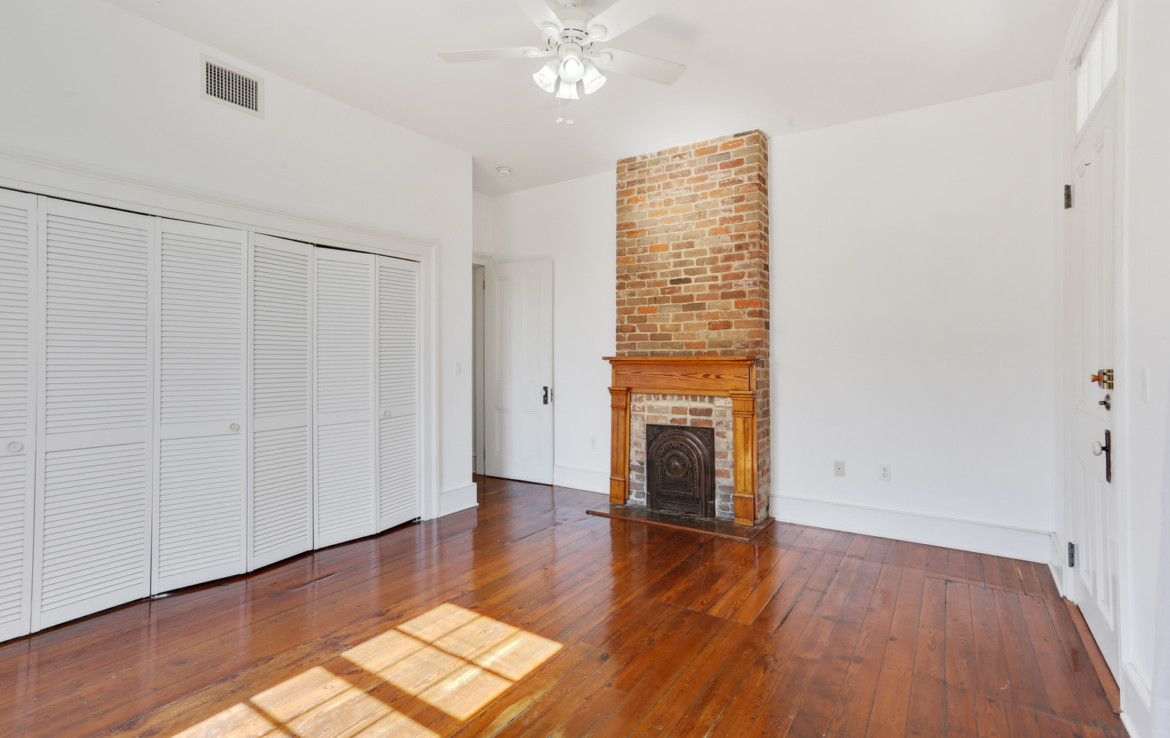 Unfurnished room with the exposed brick and fireplace
