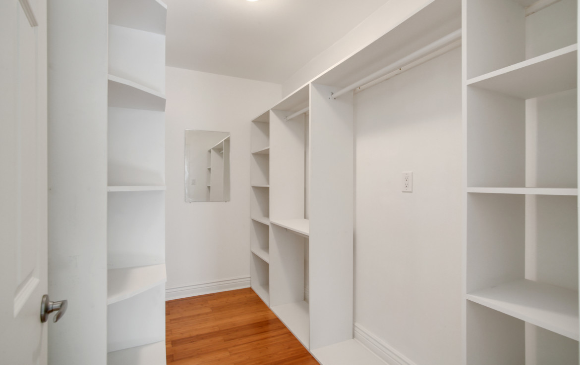Empty walk-in closet with shelving