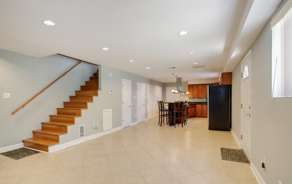 Unfurnished interior with staircase, dining area, and kitchen