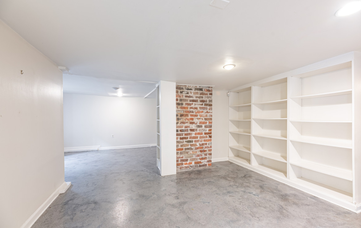 Unfurnished white room with the exposed brick