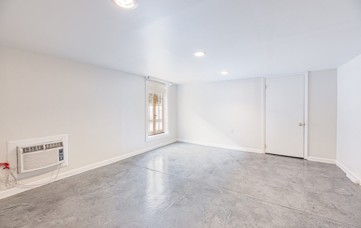 Angled view of unfurnished white room with grey marbled flooring