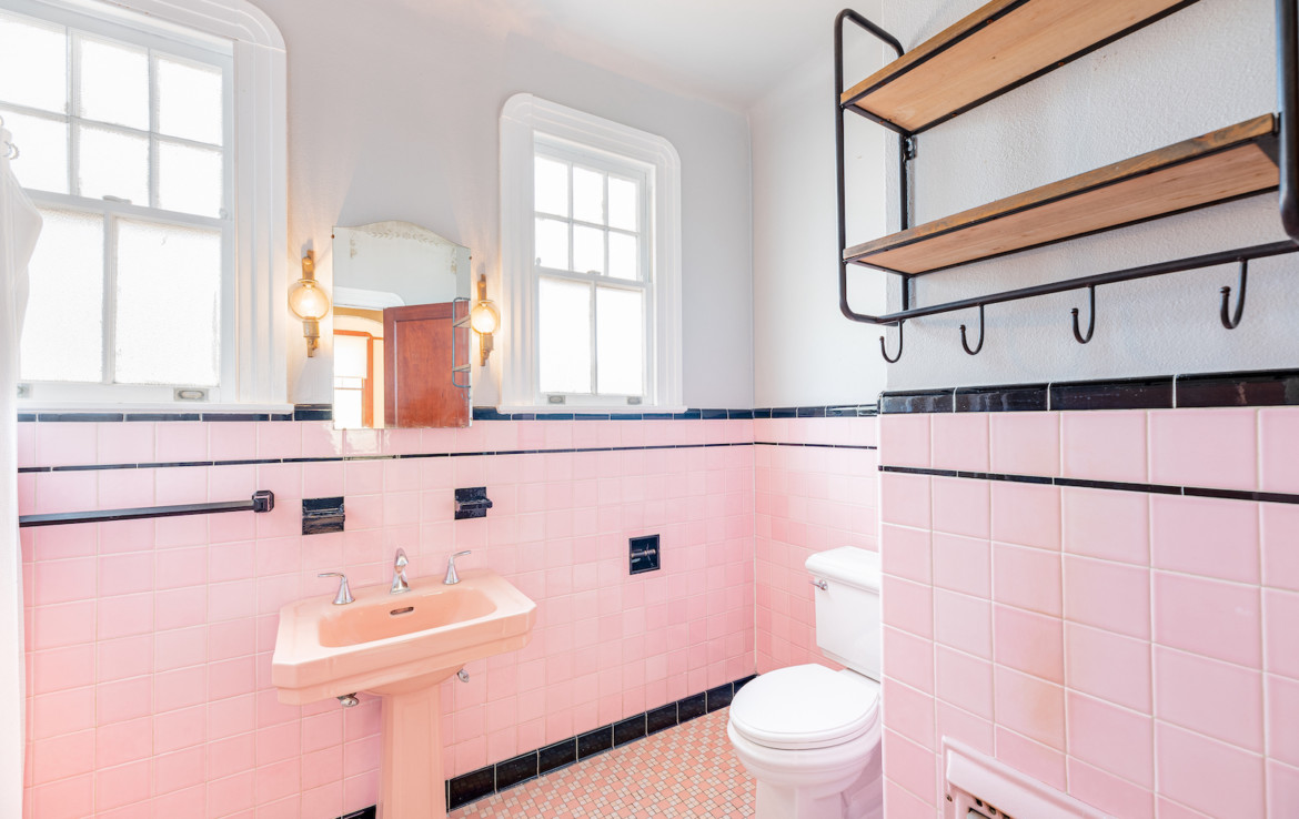 Pink tiled bathroom with toilet and sink