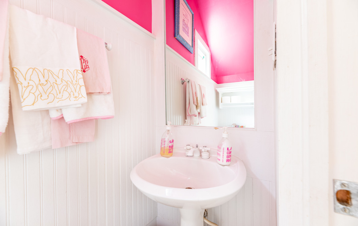 bathroom sink and mirror with pink walls