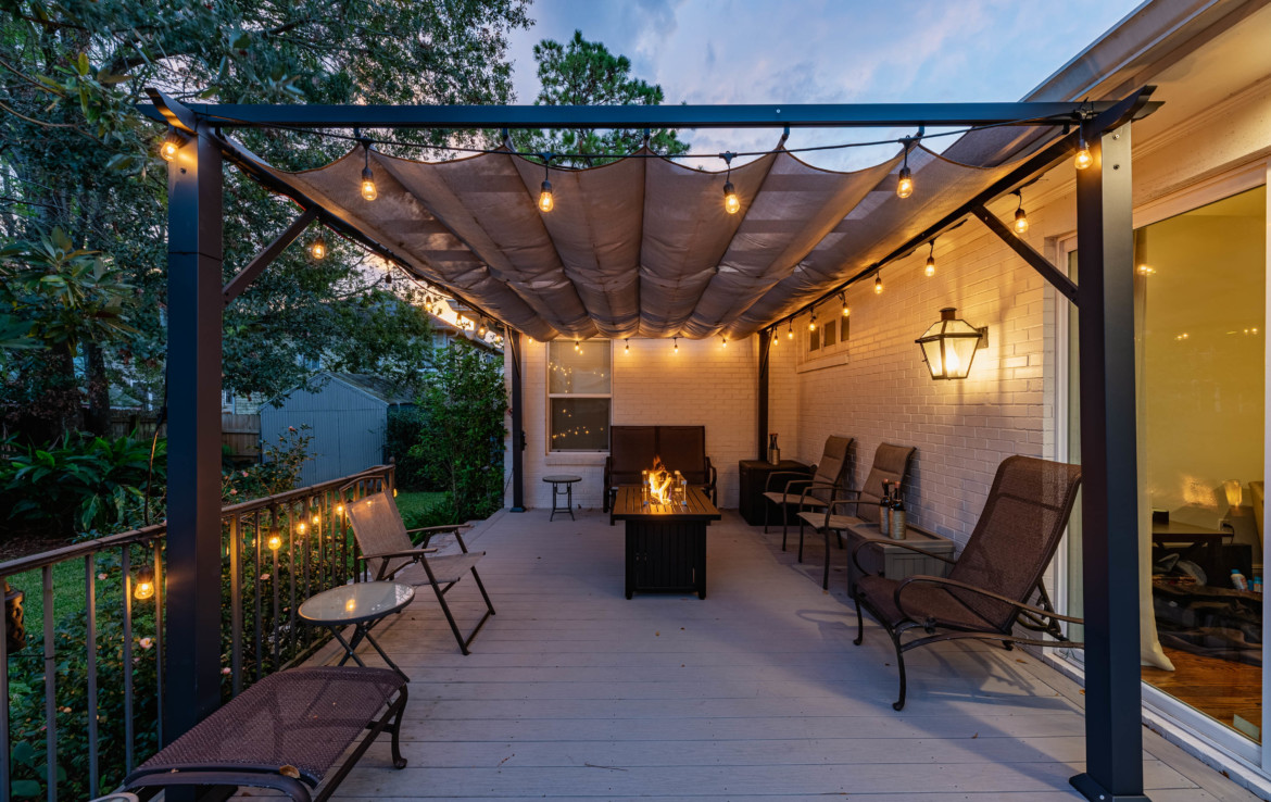 backyard with covered patio with lights and fire pit