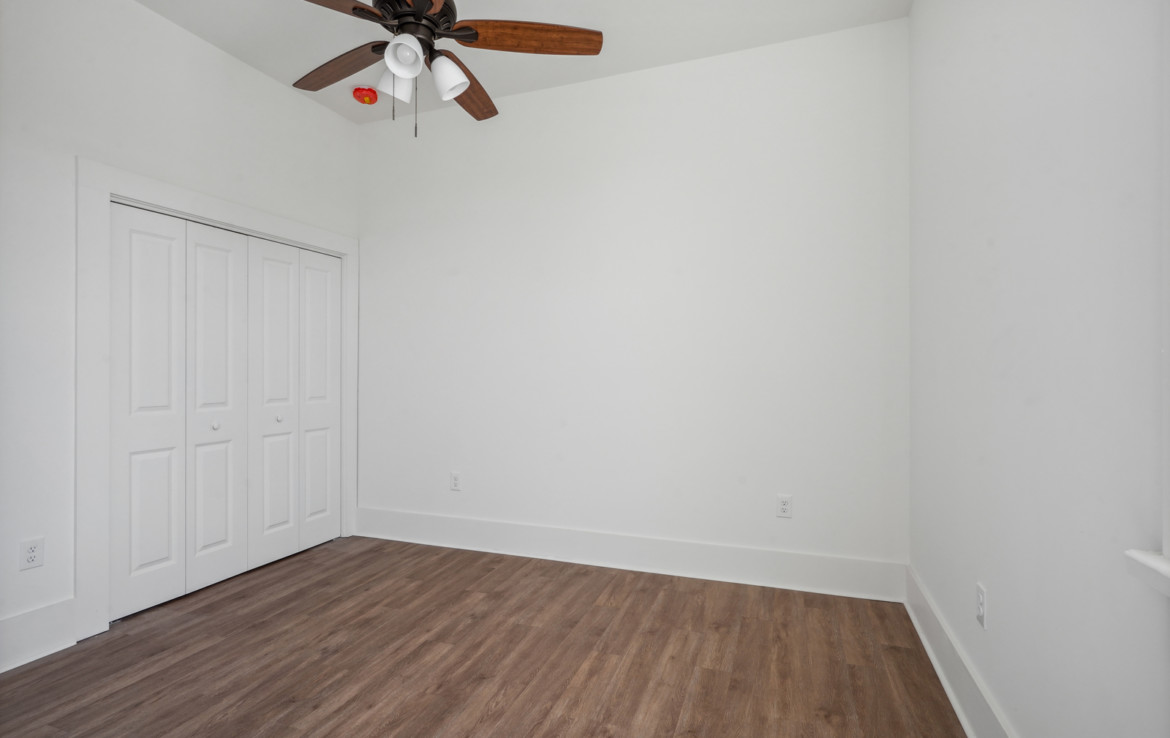 First bedroom with ceiling fan and double closet